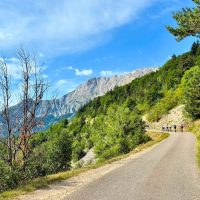 Mountain road, sunshine, riders in distance