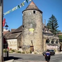 Tower in village, yellow TDF jersey, cyclist